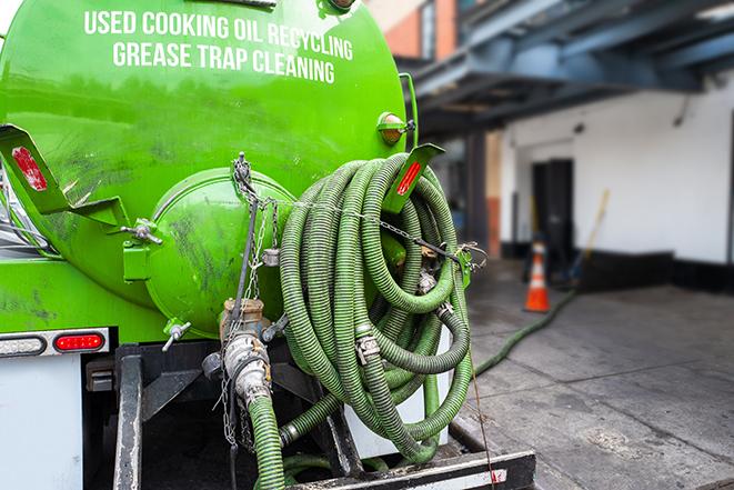 a grease trap being pumped by a sanitation technician in Hayward